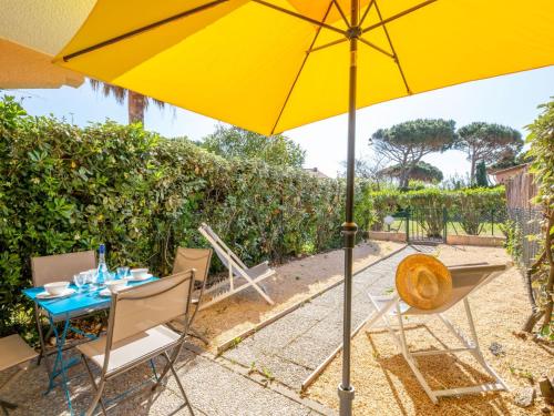 a table and chairs with an umbrella on a patio at Apartment Les Jardins de la Nartelle Beach by Interhome in Sainte-Maxime