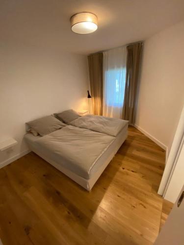 Bett in einem Schlafzimmer mit Holzboden in der Unterkunft Ferienwohnung in Lay in Koblenz