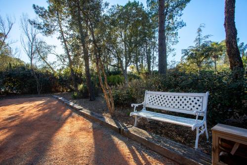 a white bench sitting on the side of a road at Appartement - Clos Saint Jean in Roquebrune-sur-Argens