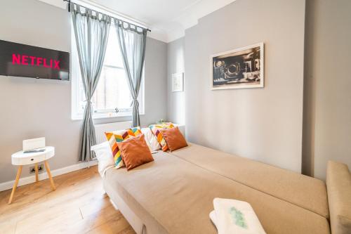 1 dormitorio con cama, sofá y ventana en ［FITZROVIA-COVENT GARDEN］CENTRAL LONDON APARTMENT en Londres