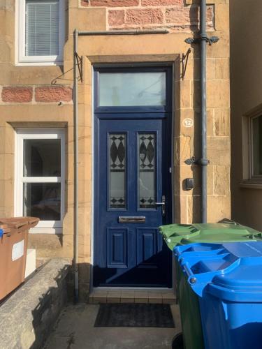 uma porta azul do lado de um edifício em Kenneth Street Apartment em Inverness