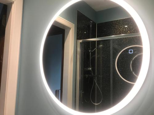 uma casa de banho com um espelho redondo na parede em Kenneth Street Apartment em Inverness