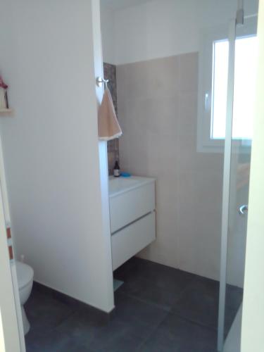 a white bathroom with a toilet and a sink at Chambre privée in Tulette