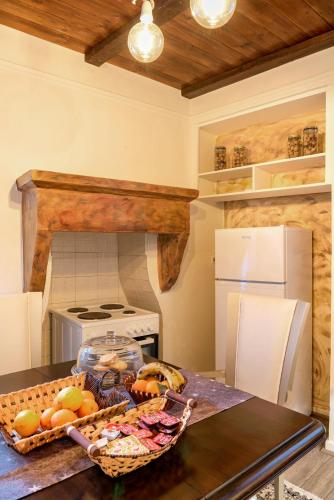 a kitchen with a table with a basket of fruit at Lykovrisi Guest House in Arachova