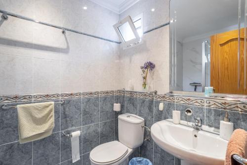 a bathroom with a toilet and a sink at Alto Rey Torrox Beach in Torrox Costa
