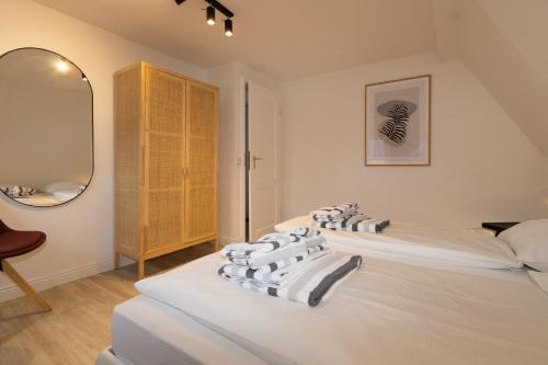 2 letti bianchi in una stanza con specchio di Kalle Blomquist a Hörnum