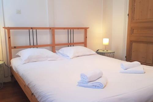 - une chambre avec un lit blanc et des serviettes dans l'établissement Little suite Bernadette, à Lille