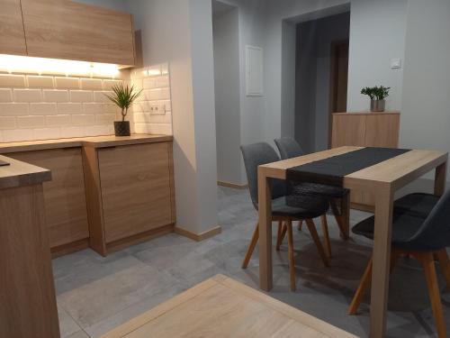 a kitchen and dining room with a table and chairs at Apartament na Słonecznej in Łączany