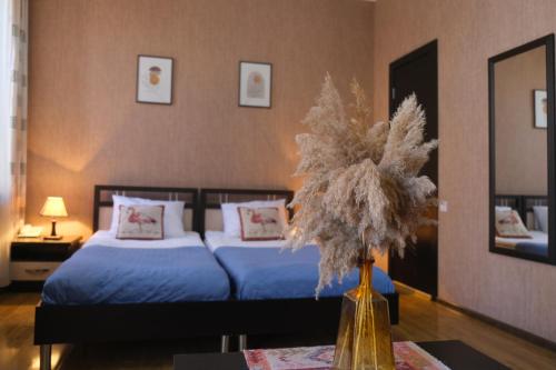 a bedroom with a bed and a vase of flowers on a table at Flamingo Hotel in Tbilisi City