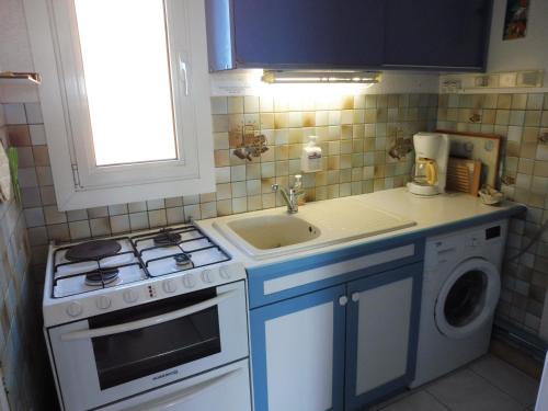 małą kuchnię z kuchenką i zlewem w obiekcie MAISONS SUR LA PLAGE Magnifique T3 mezzanine vue mer Cap d'Agde w Cap d'Agde