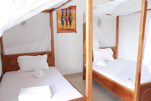 two bunk beds in a room with white walls at Mocco Beach Villa in Kendwa