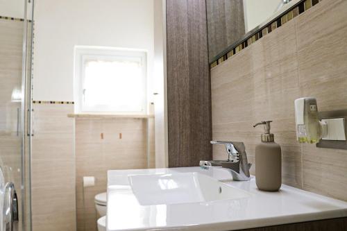 een badkamer met een wastafel en een toilet en een raam bij Casa Mirra in Peschiera del Garda