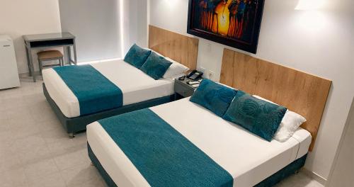 two beds in a hotel room with a fireplace at Hotel Ruittoque D Prada in Bucaramanga