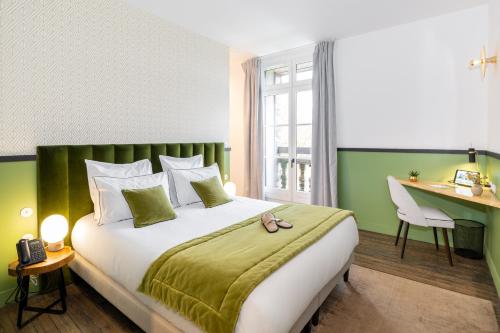 een slaapkamer met een groot bed en een bureau bij Les Jardins de Coppélia in Pennedepie