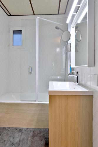 a bathroom with a white sink and a shower at Logis Hôtel Restaurant Europa in Maussac