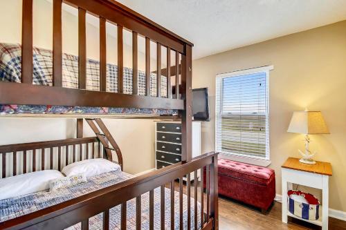 a bedroom with a bunk bed and a crib at Barefoot Bungalow in Galveston