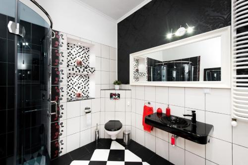 een badkamer met een zwart-wit geblokte vloer bij Apartamenty Gołębia 3 in Krakau