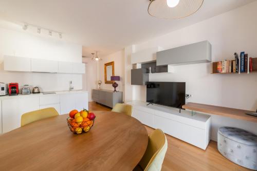 a kitchen and dining room with a wooden table with a bowl of fruit at Castalia Apartments & Rooms Duomo Taormina in Taormina