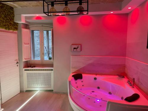 bañera rosa en una habitación con ventana en Old Town Suite en Guardiagrele
