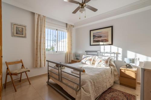 a bedroom with a bed and a ceiling fan at Casa Reina Torrox Beach Club in Torrox Costa
