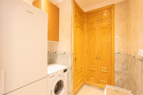 a laundry room with a washing machine and a washer at Casa Reina Torrox Beach Club in Torrox Costa