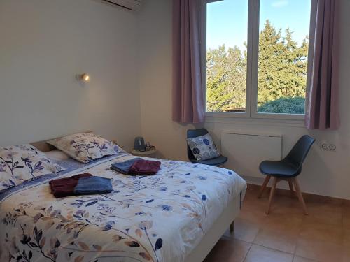 um quarto com uma cama, uma cadeira e uma janela em Chambres d'hôtes dans propriété rurale em Béziers