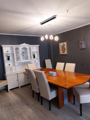 a dining room with a wooden table and white chairs at Apartment near the airport in Ytri-Njarðvík