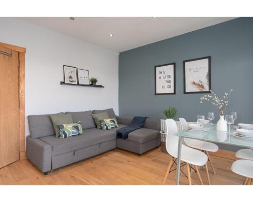 a living room with a couch and a table at Central Belfast Apartments Eden in Belfast