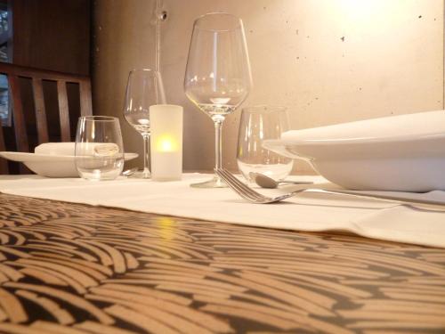 a table with wine glasses and plates on it at Eco Hotel Boutique & Spa Capitulo Trece - Adults Only in Maderuelo