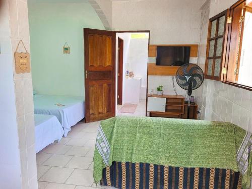 a room with a bed and a tv and a room with a bed sidx sidx at Herdeiros do Pai in Paraty