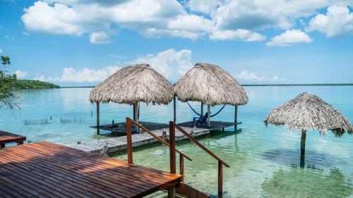 a group of umbrellas on a dock in the water at Agave-Blue in Bacalar