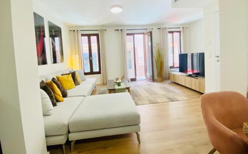 a living room with a white couch and a tv at Hotel Apartment with 2-en suite Bedrooms in Palma de Mallorca