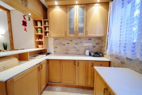 una cocina con armarios de madera y una ventana en Vila LALUKO en Zlatibor