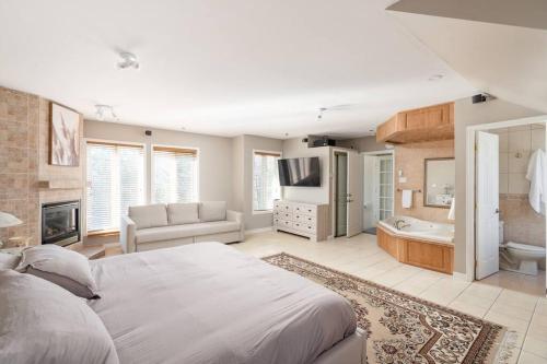 a bedroom with a large bed and a bathroom at Majestic Retreat in the Laurentians in Morin Heights