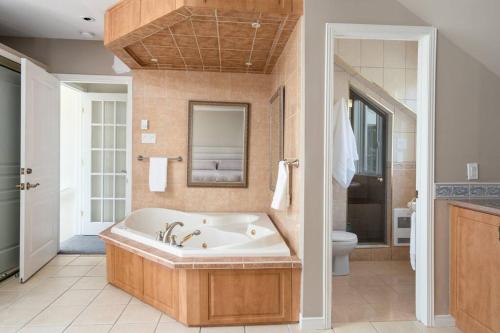 ein großes Bad mit einer Badewanne und einem WC in der Unterkunft Majestic Retreat in the Laurentians in Morin Heights