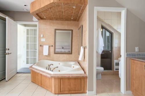 a large bathroom with a tub and a toilet at Majestic Retreat in the Laurentians in Morin Heights