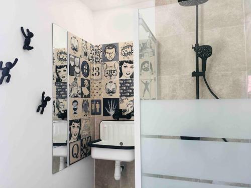 a bathroom with a sink and a wall of pictures at T3 VUE MER A 20 mètres de la PLAGE ANGLET BIARRITZ in Anglet
