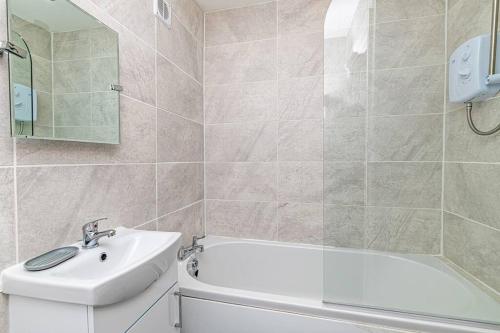 a bathroom with a sink and a bath tub and a mirror at 2 Bed Holiday House within Walton Area, Liverpool in Liverpool