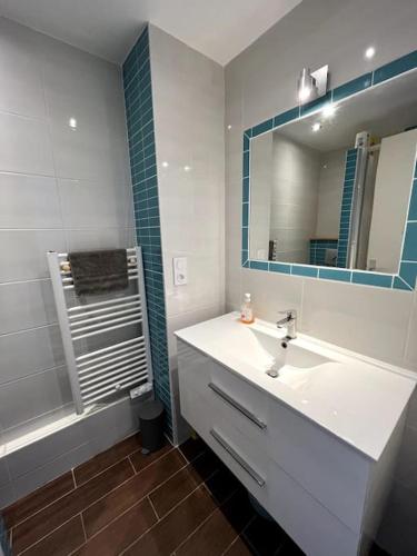 une salle de bain avec un lavabo, un miroir et une douche dans l'établissement Studio équipé moderne à deux pas de la plage, à La Rudelière