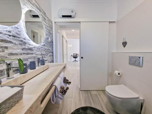 un bagno con lavandino, WC e specchio di Apartment Praia Rocha Candimar Confort a Portimão