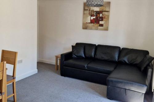 a black leather couch in a living room at Greenhithe Cosy Apartment, Netflix and Sport Channels in Kent