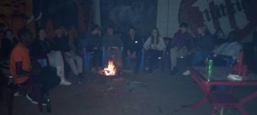 Kabarondo的住宿－AKagera Neighbors Homestay A，一群人坐在一个房间里,围着火堆