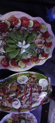 Kabarondo的住宿－AKagera Neighbors Homestay A，桌上有两盘蔬菜食品