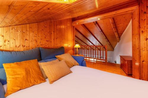1 dormitorio con sofá azul y paredes de madera en Apartamento Los 3 Reyes, en Valderrobres