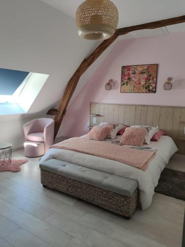 a bedroom with a large bed and a chair at Chambre d'hôtes in Beaumont-Pied-de-Boeuf