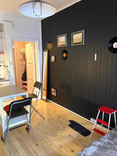 a room with a black wall with a table and chairs at Bohemian studio in Etu-Töölö in Helsinki