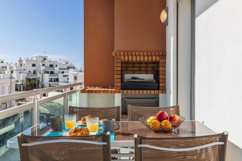 a table with a bowl of fruit on a balcony with a fireplace at Apartamento Michel Sea View Algarve in Albufeira