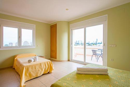 カルプにあるVilla Almendros - PlusHolidaysのベッドルーム1室(ベッド2台、大きな窓付)