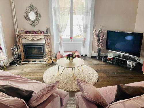 a living room with a couch and a tv and a table at Appartement de standing à Vallorbe in Vallorbe