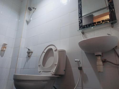 a bathroom with a toilet and a sink at City Inn Antang in Palangkaraya